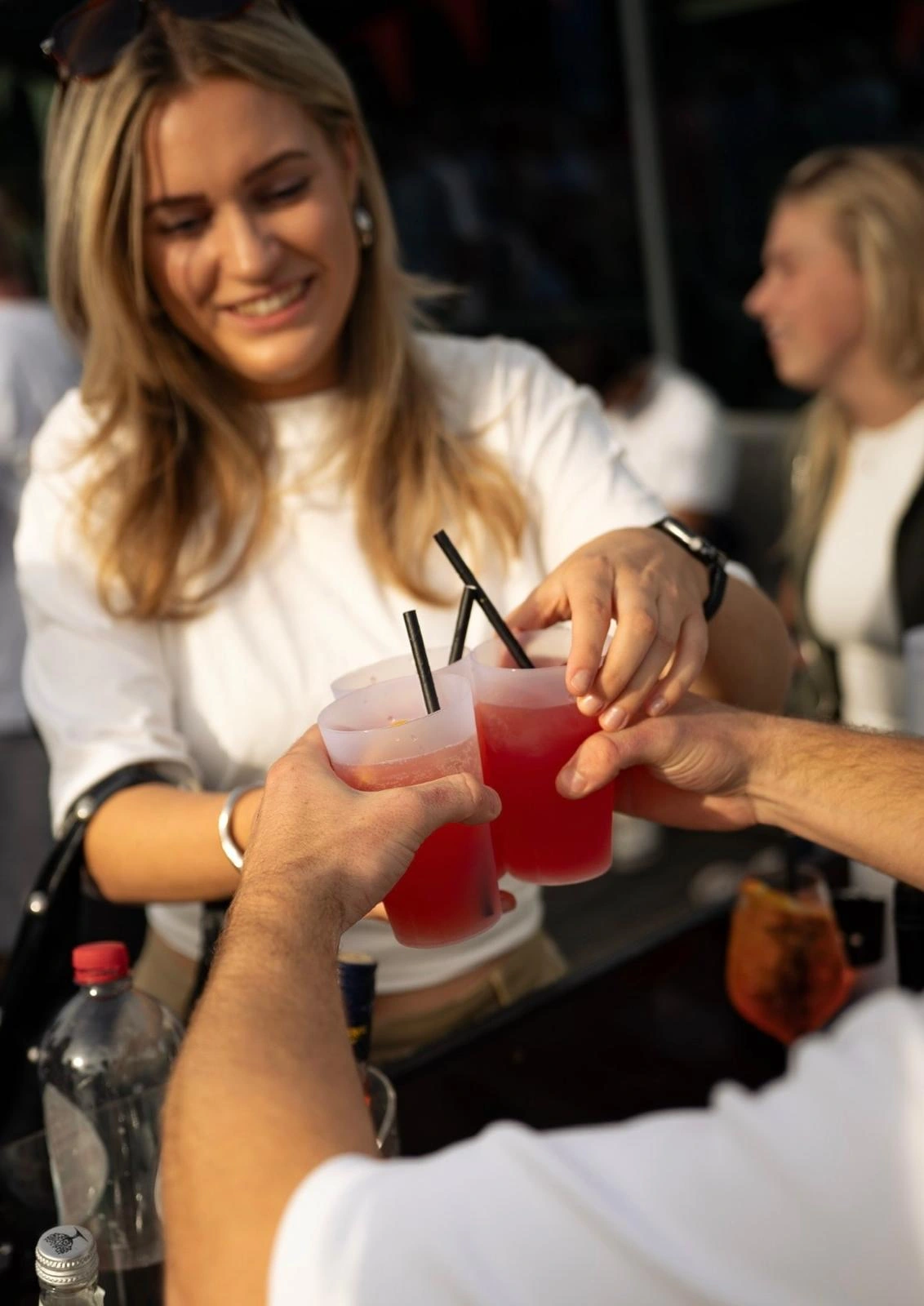 Gasten proosten met roze drankjes aan de bar